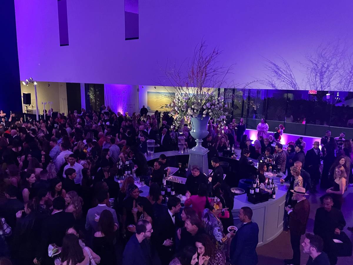 a crowd of people at a party in the de young museum