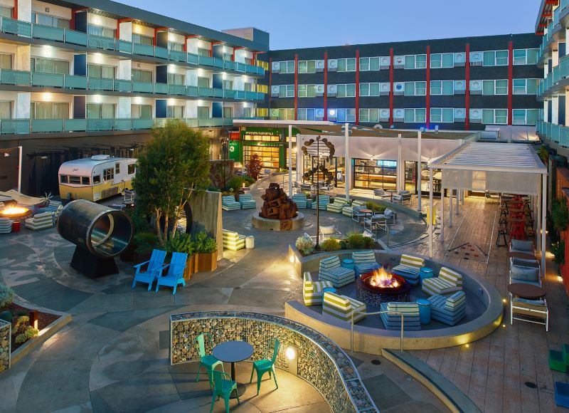Hotel Zephyr's courtyard with chairs by the fireplace, shuffleboard and other activities.