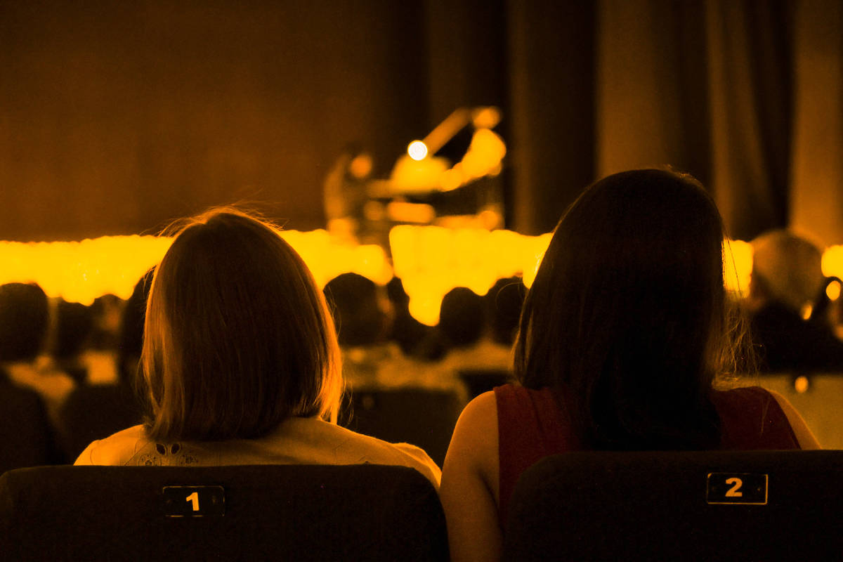 Two audience members watch a Candlelight concert.