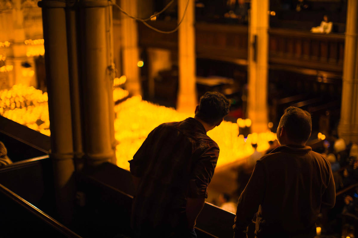 Two audience members watch a Candlelight concert from a balcony.