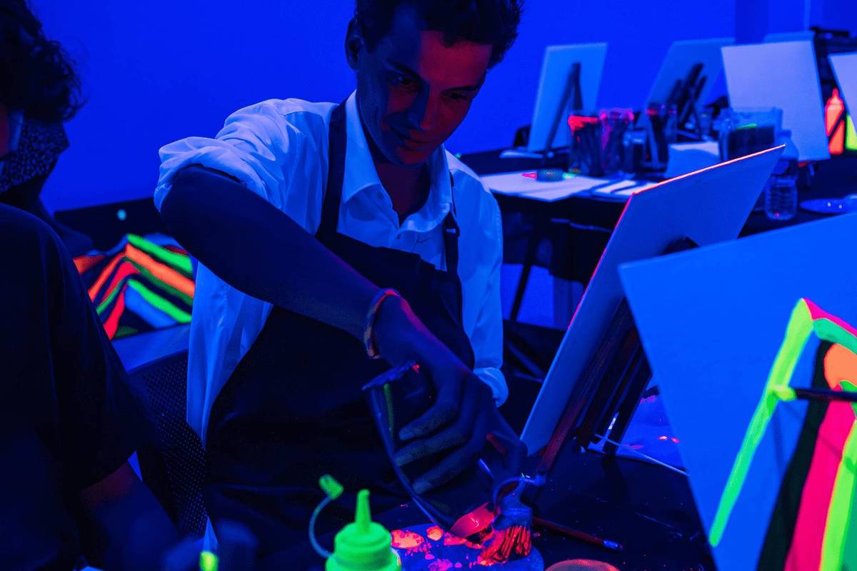 man painting in fluorescent lights at neon lights