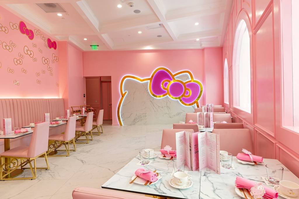 the hello kitty cafe with pink walls and dining tables