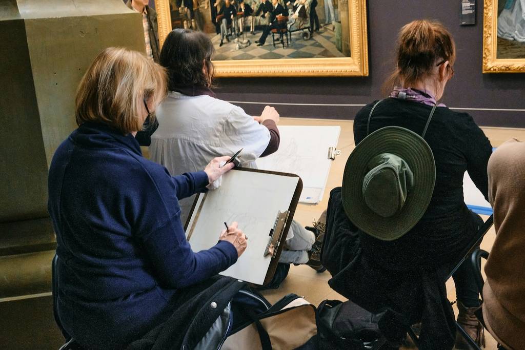 gente dibujando en una galería