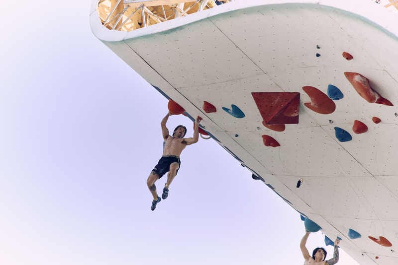 A climber hangs from a wall at the North Face Climb Festival