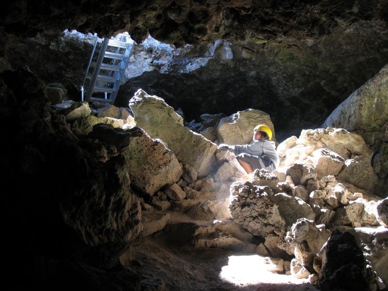 A person explores a cave at Lava Beds National Park