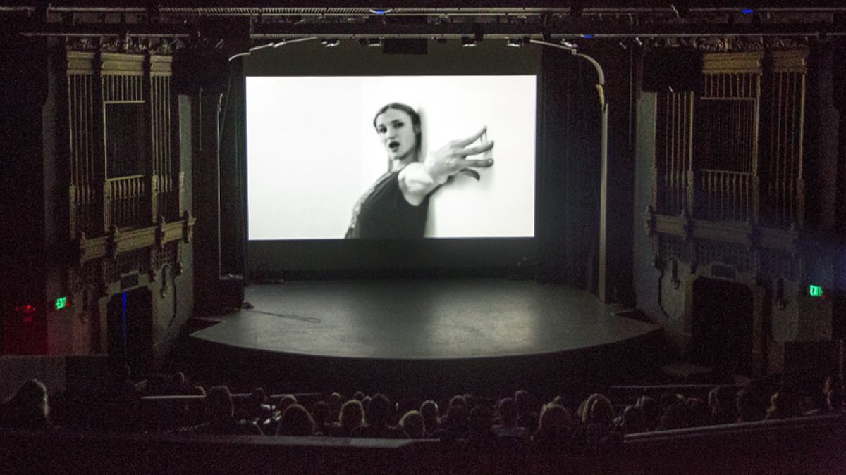 a cinema screen is lit up with a black and white image of a women in the brava arts center