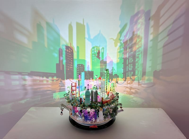 A small city sculpture with shadows reflecting larger cityscape