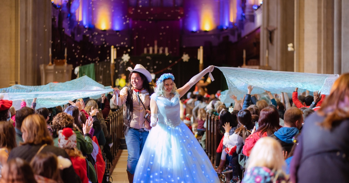 two Christmas characters walk down center aisle of Grace Cathedral