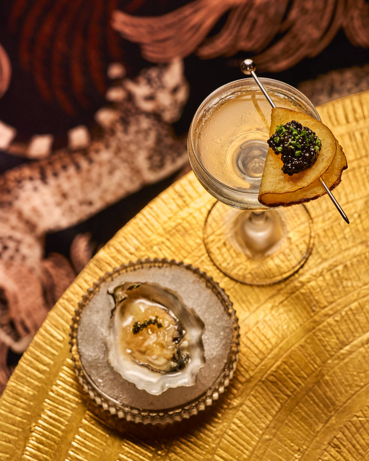a martini and an oyster on a table