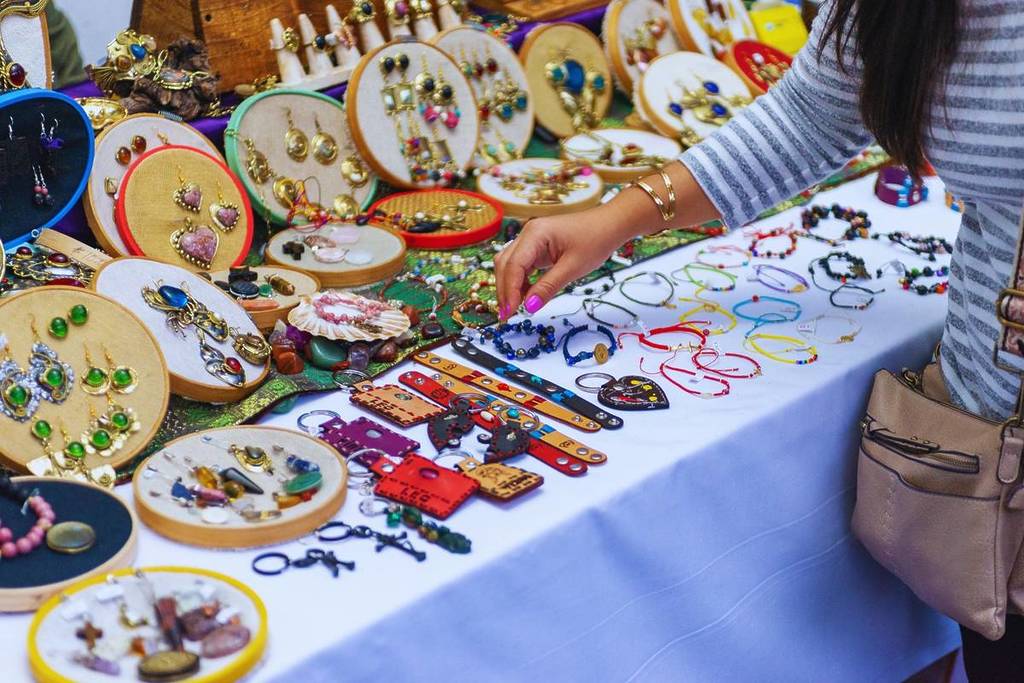 Una persona echa un vistazo en una feria de artesanía al aire libre.