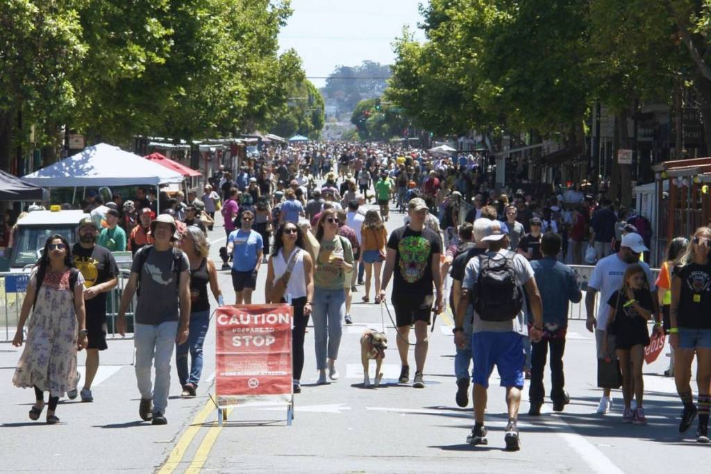 Crowds walk down a car free street at Sunday Streets San Francisco