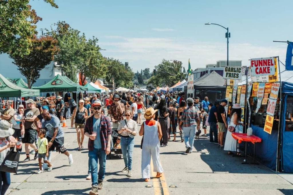 People walk between tents and vendors at Laurel StreetFair