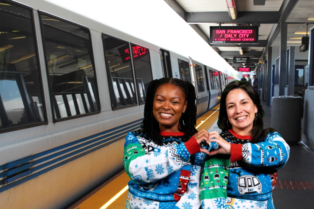 Modelos con el jersey navideño de BART y en una estación de BART