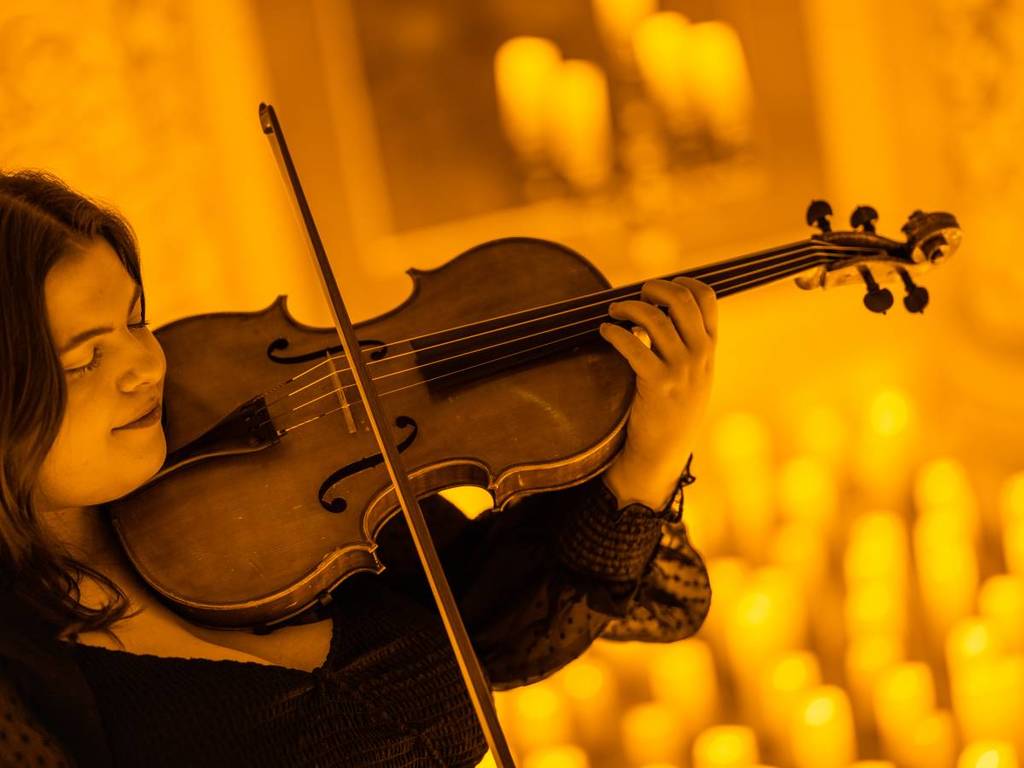 A musician playing the violin at a Candlelight concert.