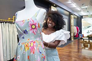 A woman adjusts a dress at Mabel Brempong