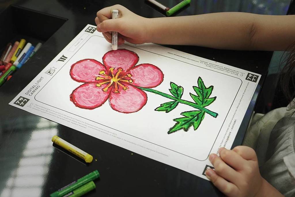 A child creating a work of art to be projected at the Digital Light Canvas Sketch Factory