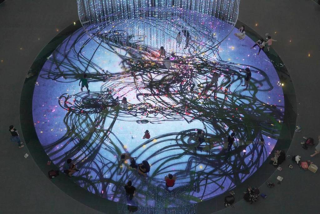 Flocks of people walking along Digital Light Canvas' display collectively creating a unique piece of art