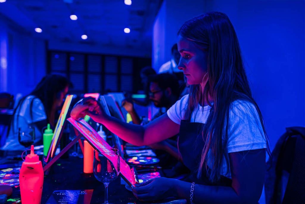 A girl painting at Neon Brush.