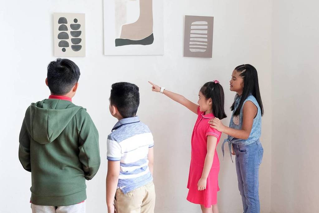 Children at an exhibition pointing at artworks, top educational experiences for kids