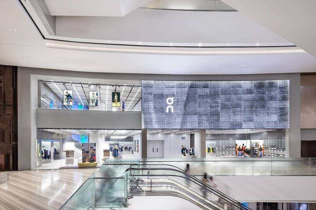 A view of On in Singapore's Changi Airport, with an escalator in the foreground.