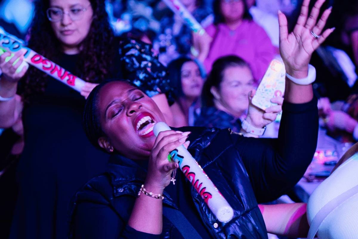 Woman singing in the middle of a big crowd at the Bingo Loco party event