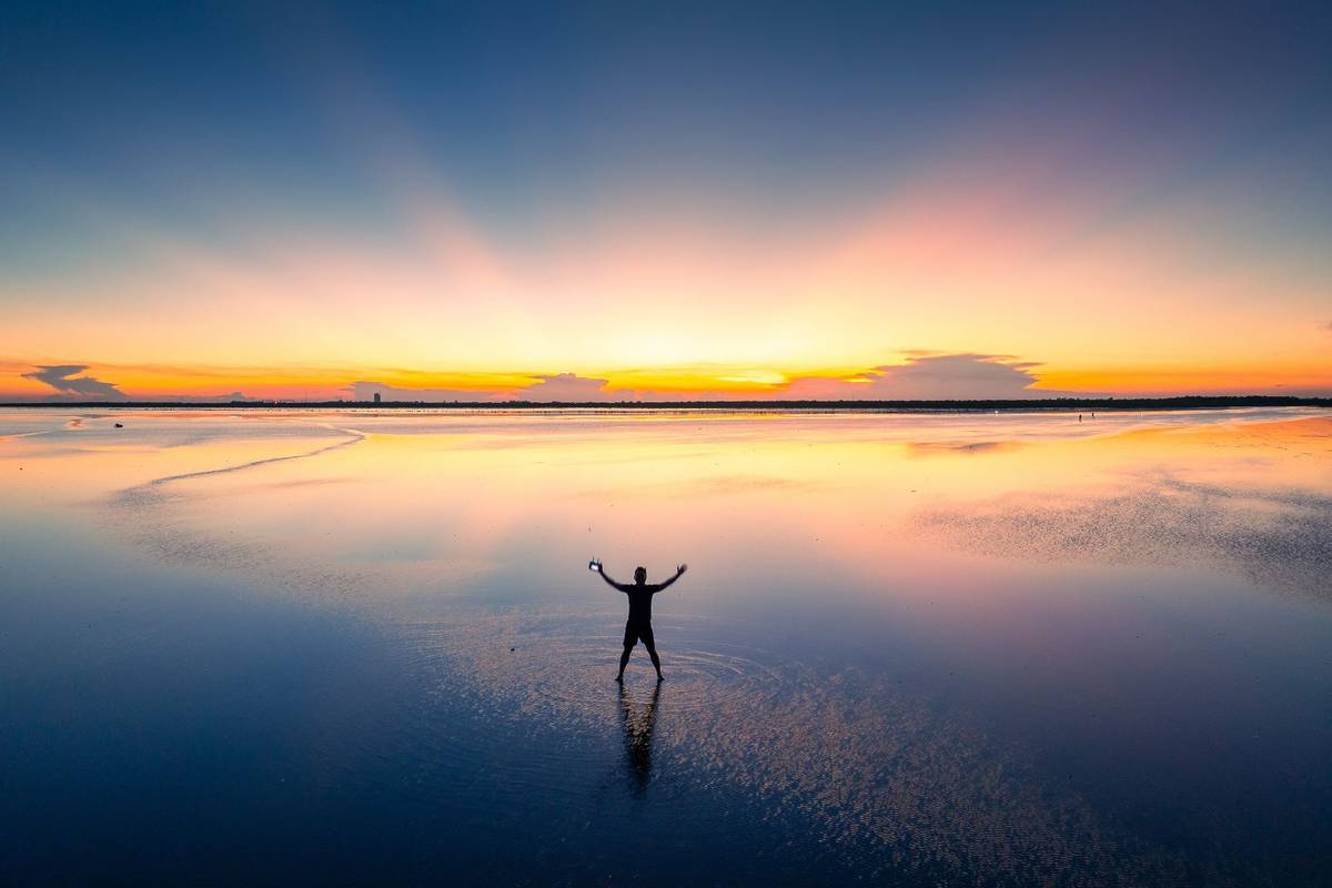 man feels like walking on water at Thai Binh Infinity Beach in Vietnam Asia's Answer To Bolivia's Salar de Uyuni