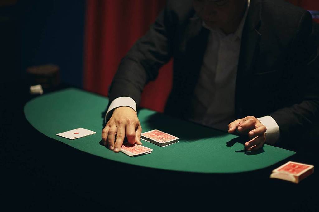 A magician performing a magic trick featuring a deck of cards