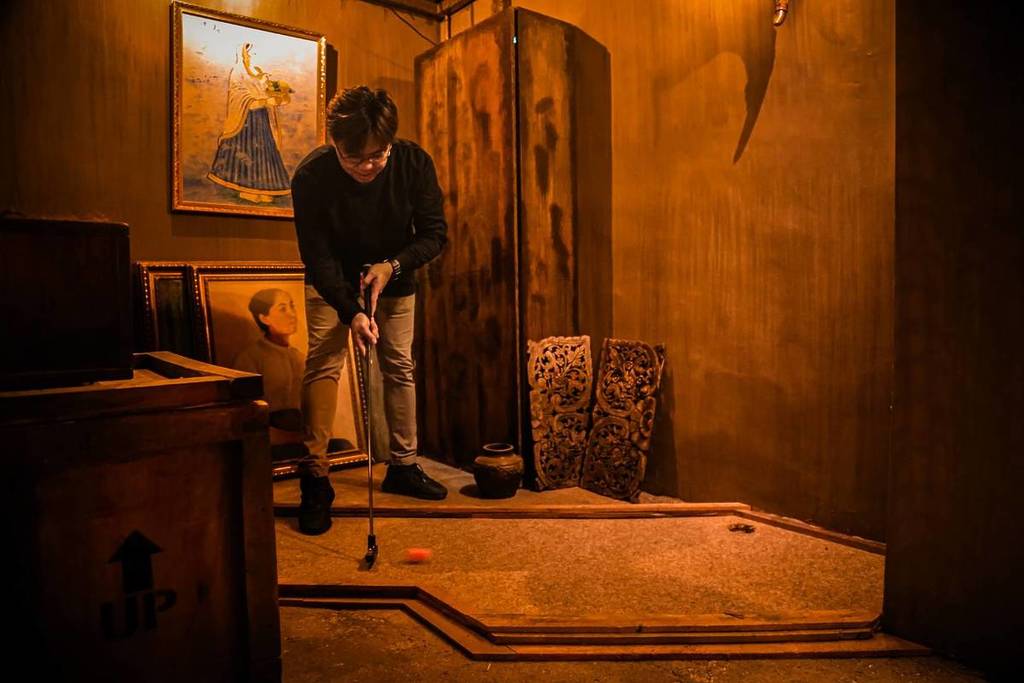 A mini-golf player putting to get the next clue