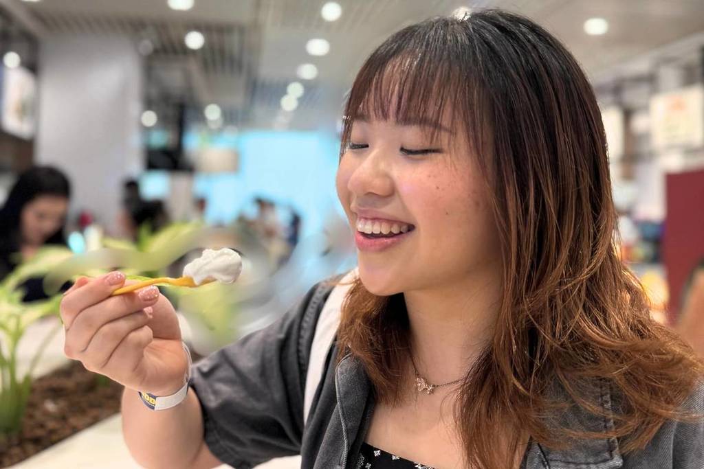 A woman taking a bite out of an ice cream at the Official Jewel Food Trail