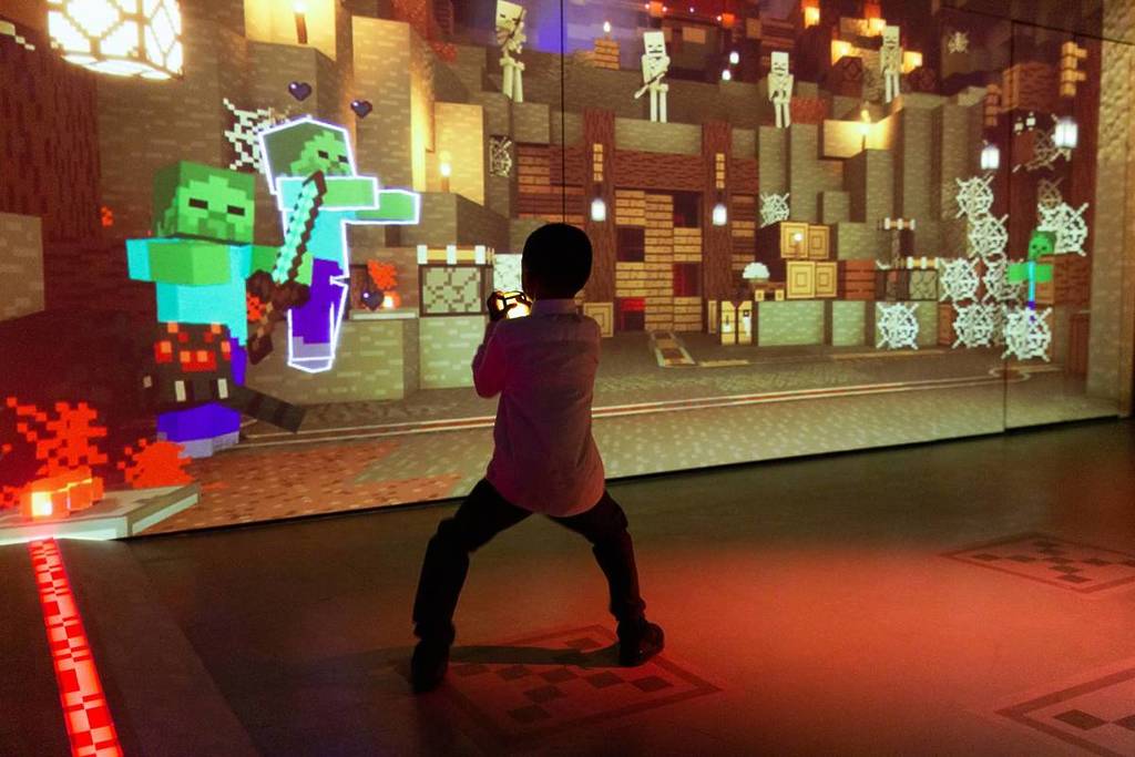 A child facing off against Minecraft's zombie mobs in this interactive experience