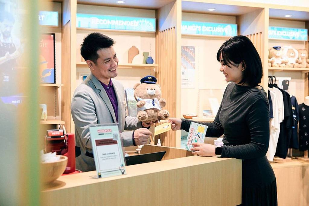 A woman exchanging MONOPOLY Money at one of the many Jewel Changi partner stores along the MONPOLY: HIDDEN - Changi Boulevard trail