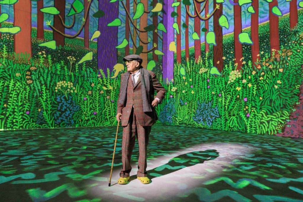 David Hockney stood in front of his work projected at IMBA Singapore
