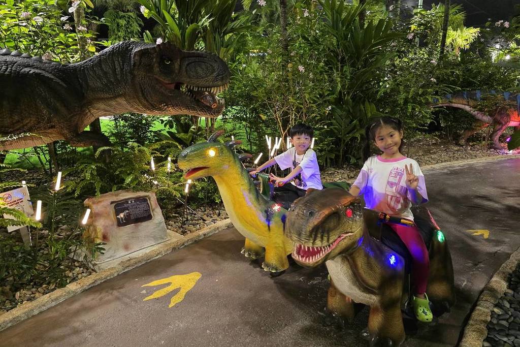 Two children happily riding small dinosaurs along the Dino Putt course at clubFACE