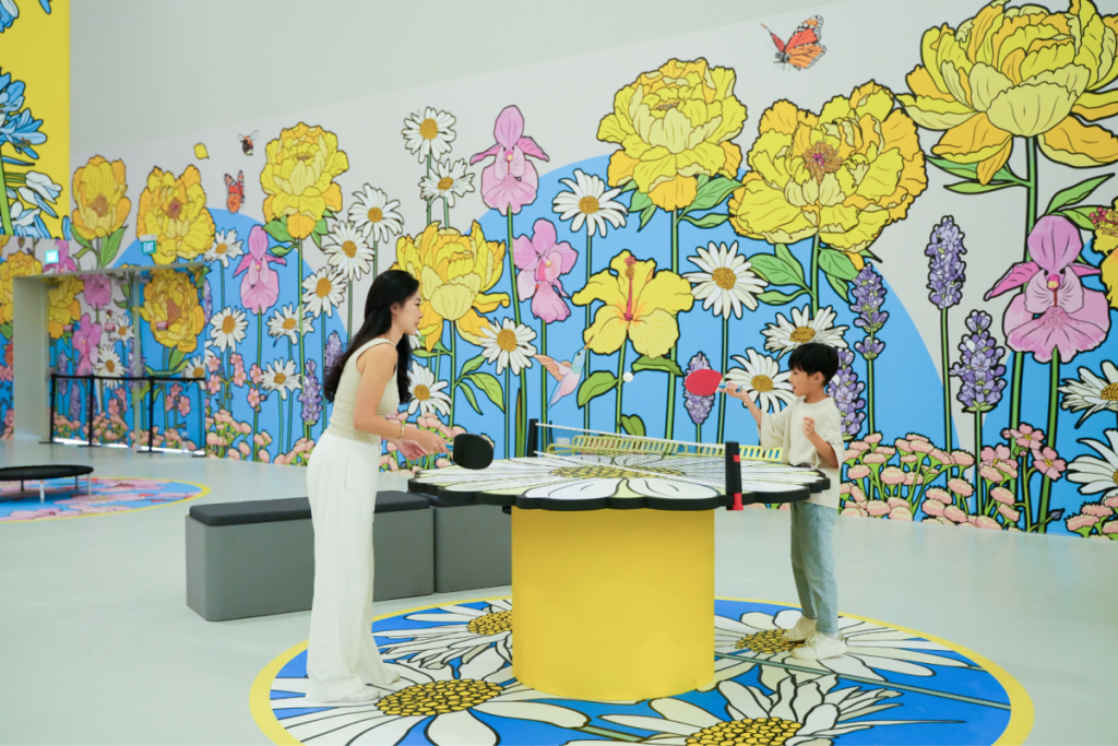 A woman and child playing table tennis at IMBA's Bloomyard by Graphic Rewilding