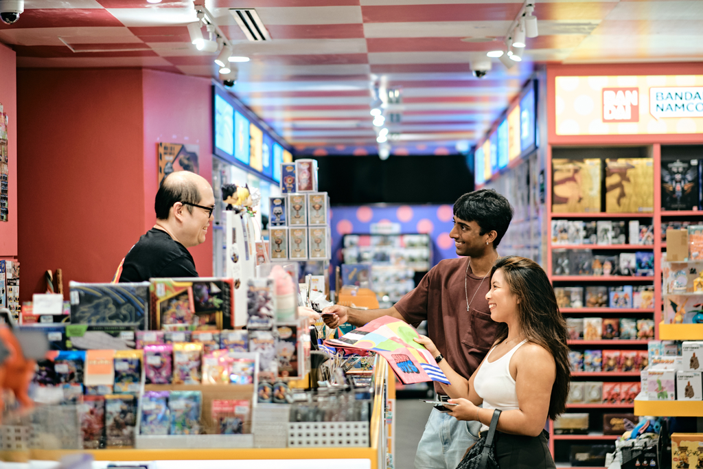 A couple exchanging MONOPOLY money for goods at one of the many vendors along the HIDDEN: MONOPOLY - Suntec City trail