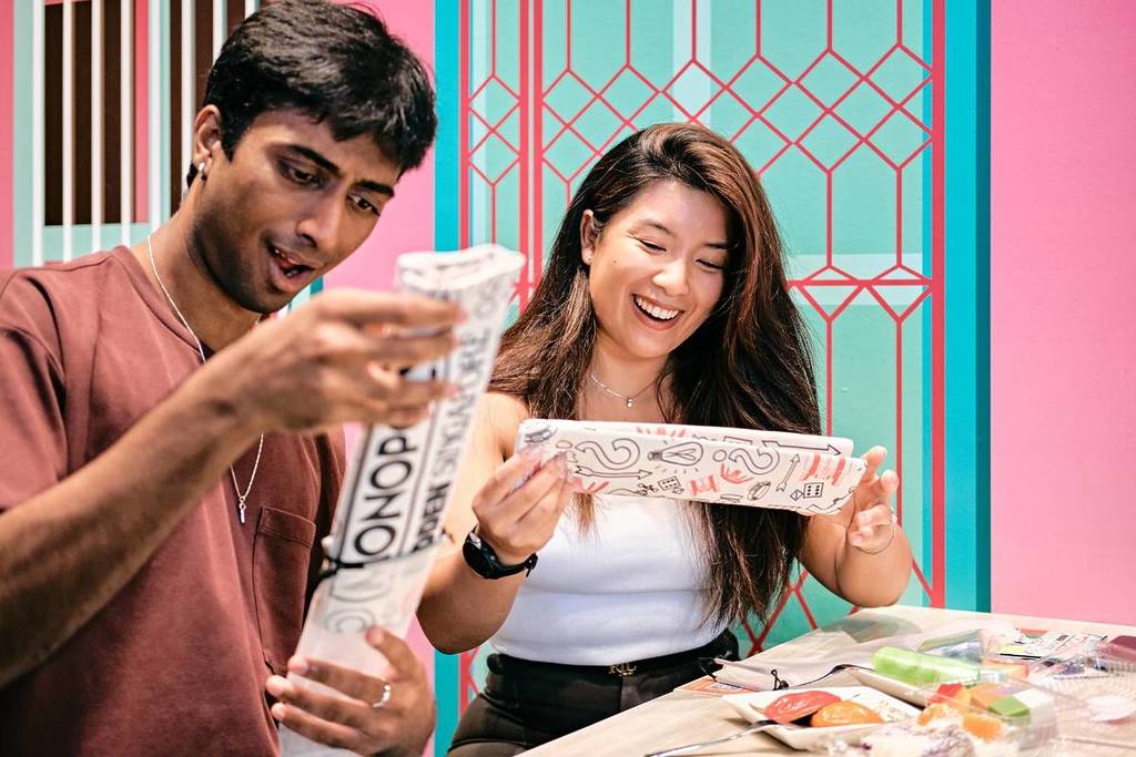 A couple navigating the MONOPOLY: HIDDEN - Suntec City trail