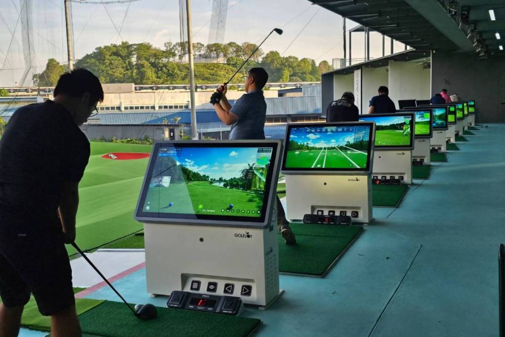 Golfers hitting balls at the clubFACE Driving Range bays 