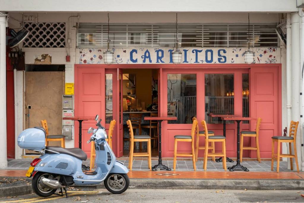 the exterior of carlitos restaurant in singapore with a blue motorbike