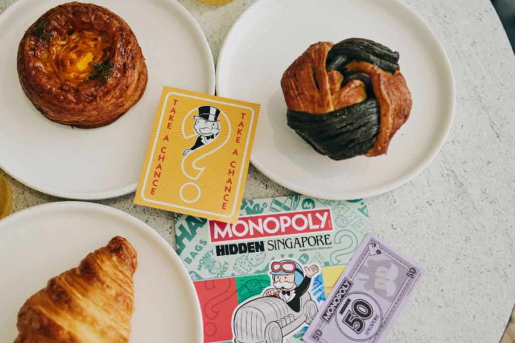 A series of baked goods plated on a table among a CHANCE Card and MONOPOLY Money