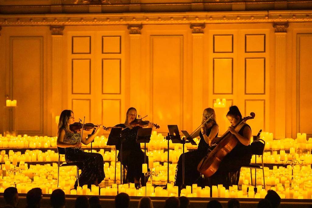 A string quartet performing amid a sea of candles at a Candlelight concert at Musikaliska Kvarteret in Stockholm