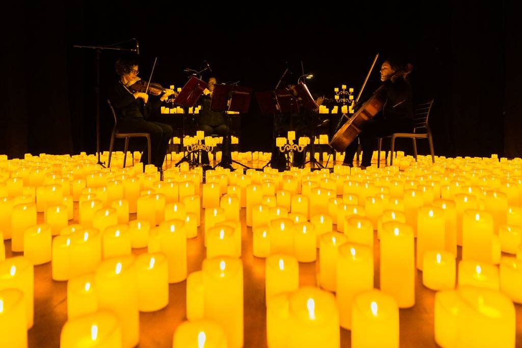 Streichquartett spielt bei einem Candlelight-Konzert auf der Bühne, umringt von zahlreichen Kerzen
