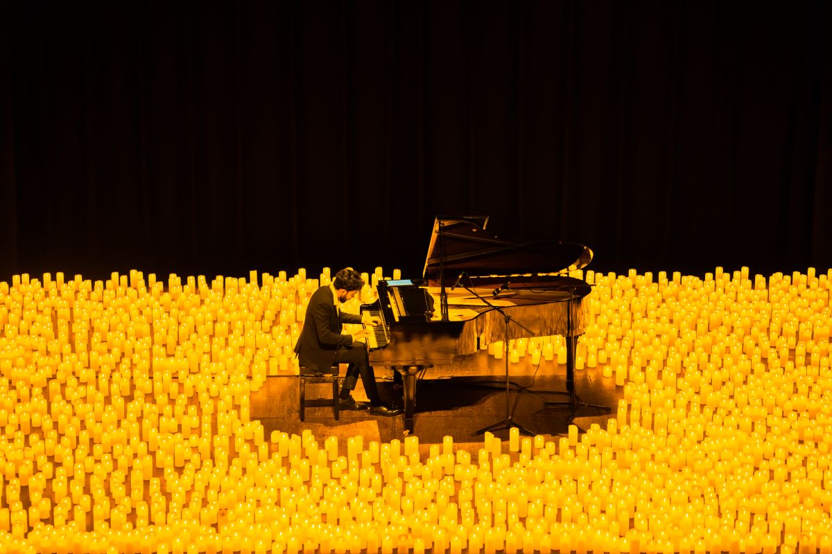 Klavierspieler spielt bei einem Candlelight-Konzert auf einem Flügel, umgeben von etlichen Kerzen