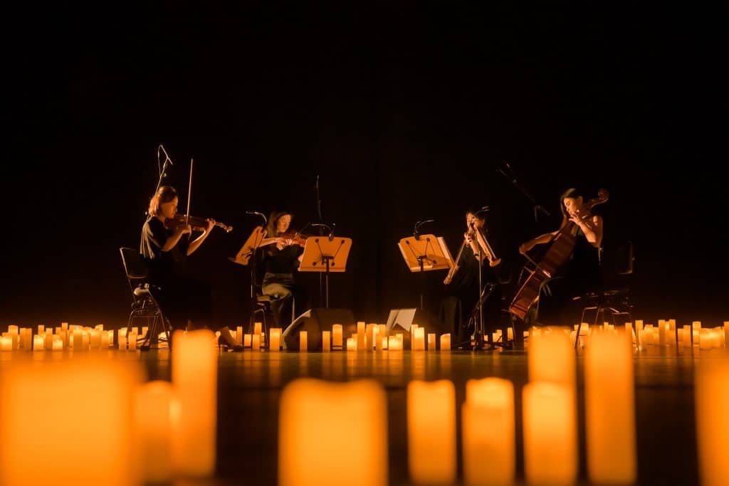 quartet on stage surrounded by candles