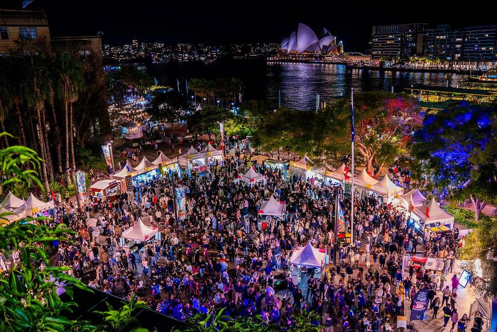 crowds gathered around Circular Quay for the annual Bastille festival with the Opera House lit up in the background