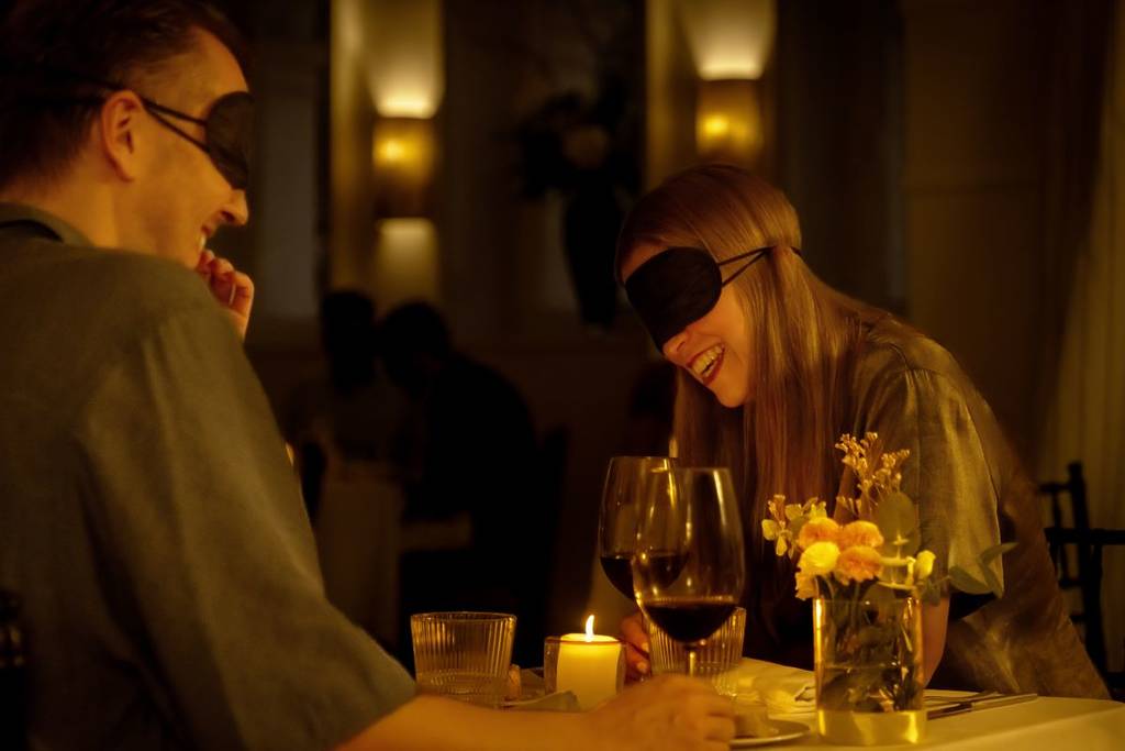 A woman laughing with her date at Dining in the Dark.