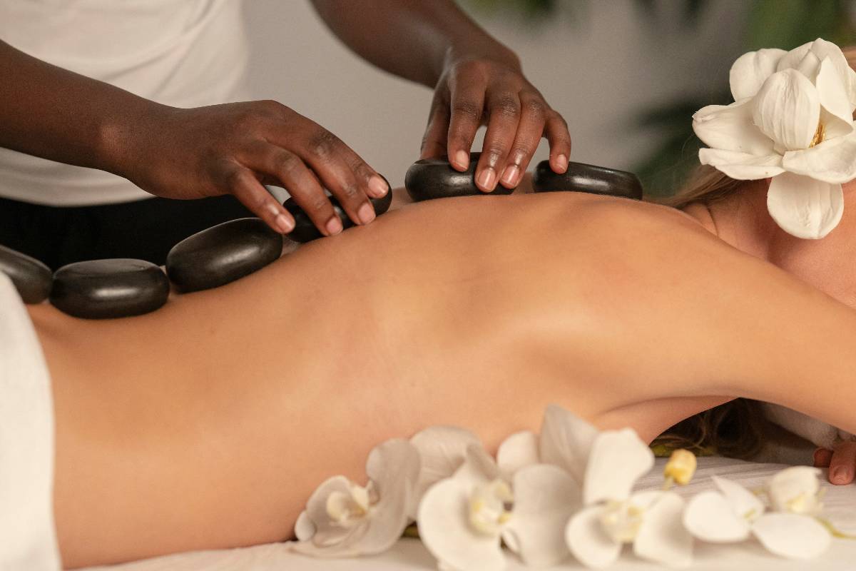 A woman getting a hot stone massage treatment at a spa