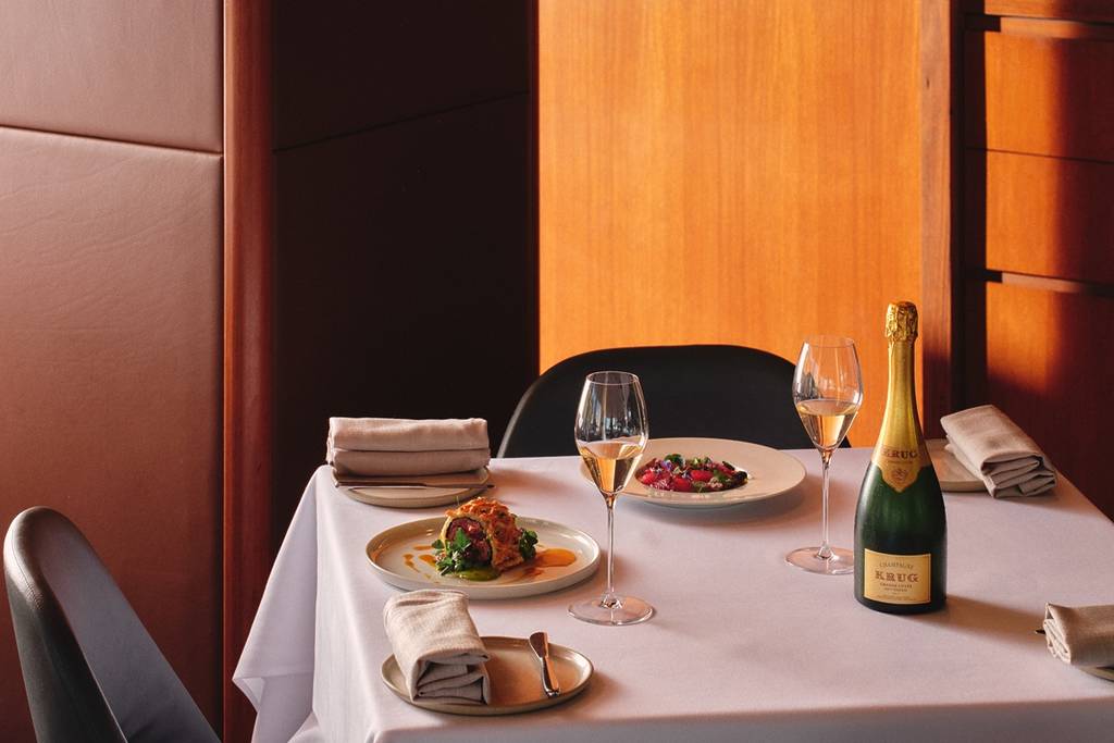 Champagne and gourmet food on a white tablecloth at Aria restaurant in Sydney.
