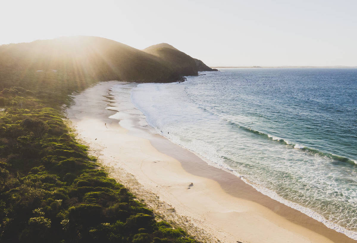 Coastal views across Elizabeth Beach in Booti Booti National Park, with the ocean on one side and rainforest on the other