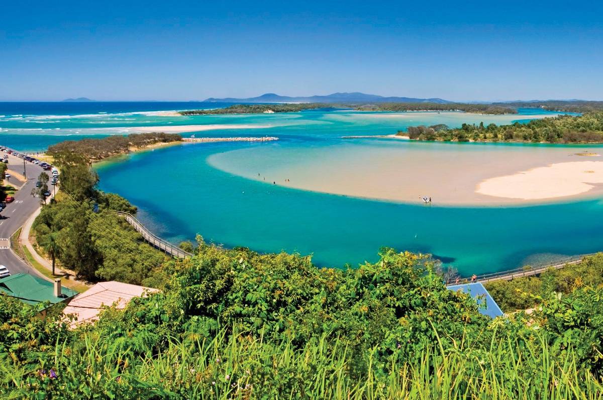 A view of Nambucca Heads with bright blue waters and a winding road along the coastline