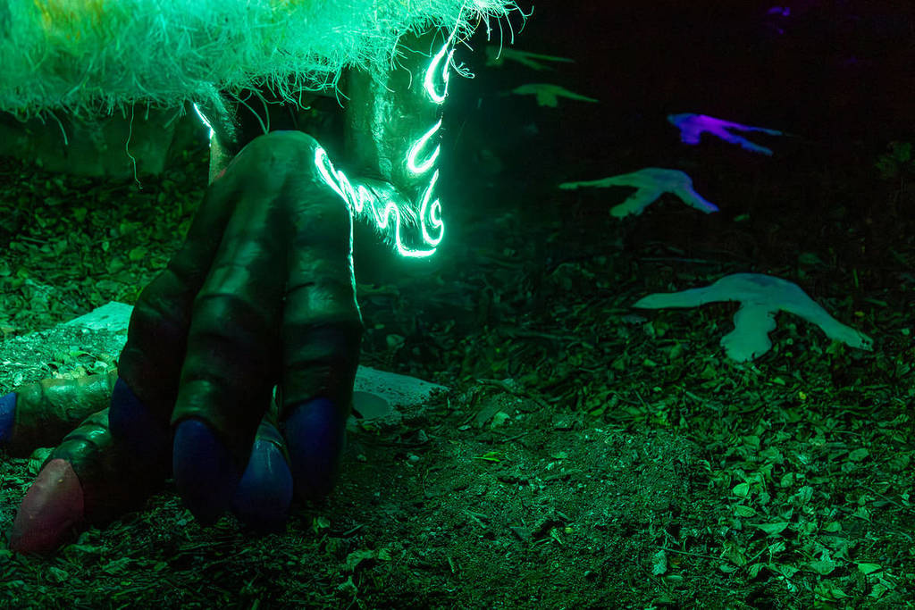A giant, glowing, green claw of an animal is pictured. There are footprints next to the claw.
